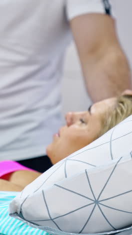 loving man stands at the bed of his pregnant wife. blonde lady breathing deep to relief painful contractions. vertical video