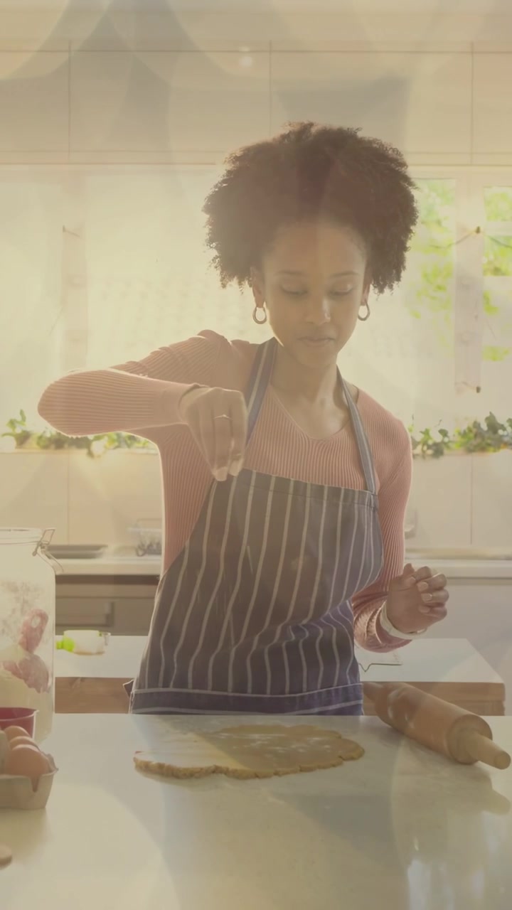 Video verticale: Donna che spolvera e modella l'impasto in cucina, mentre un uomo con un tablet segue la ricetta.