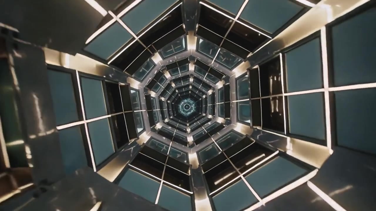 Telecamera in movimento che inizia a scivolare lungo un tunnel esagonale, mostrando pannelli a specchio, vetro e LED nel condotto.