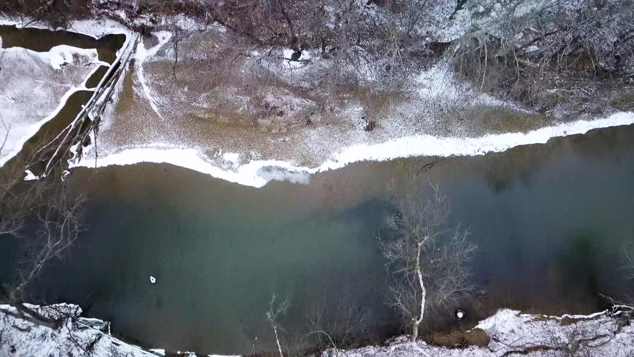 aéreo de arriba hacia abajo paisaje escénico de invierno, bosque cubierto de nieve y río blanco