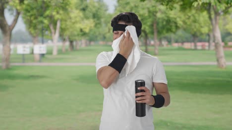 Happy-Indian-man-wiping-sweat-and-drinking-water