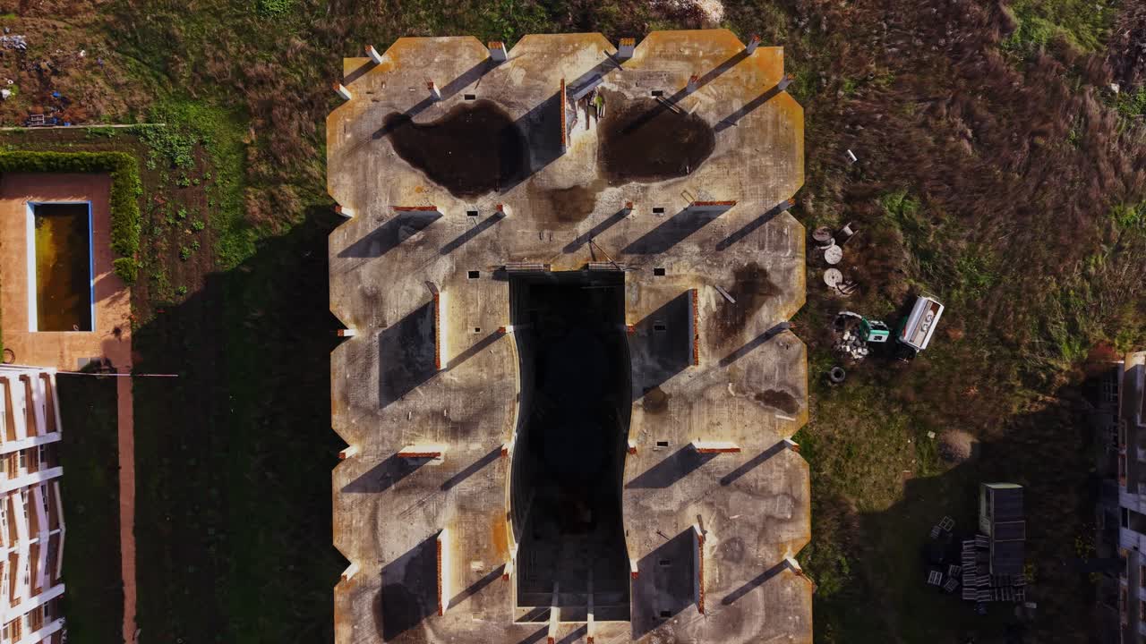 Aerial view of abandoned building surrounded by overgrown land
