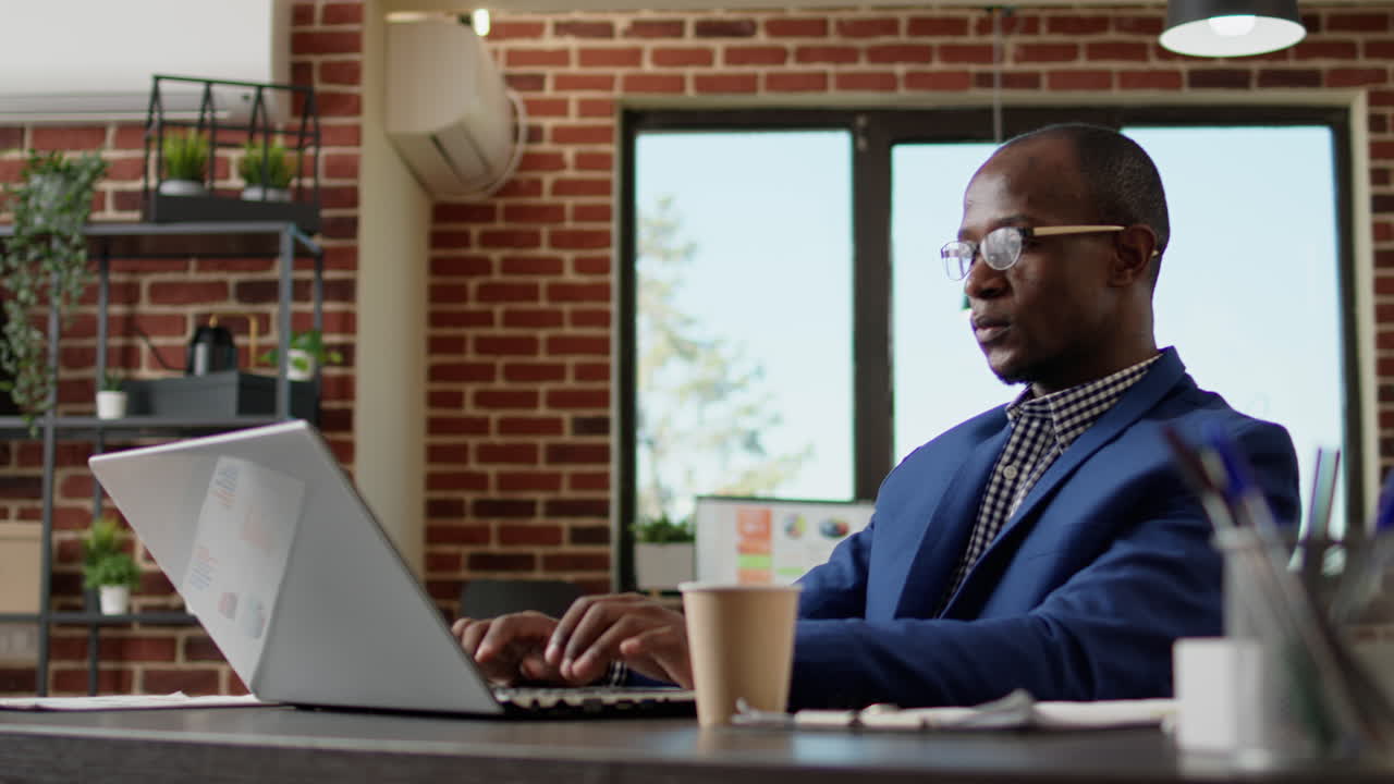 Company employee writing business report on laptop