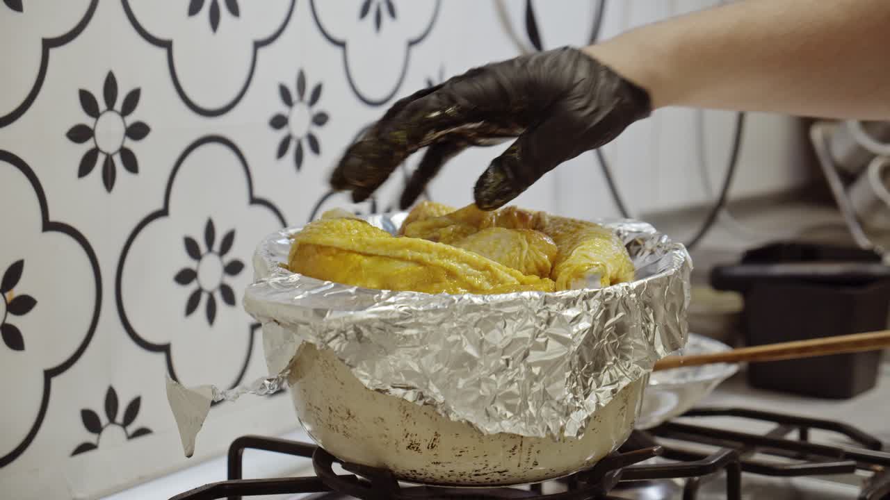Lo chef adagia cosce di pollo speziate su carta stagnola.