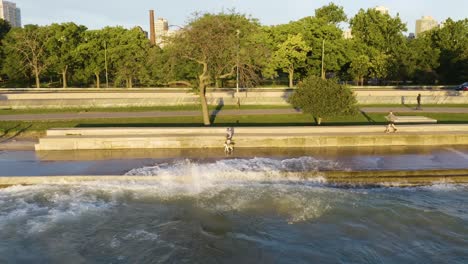 60 frames per second - static aerial shot of people exercising along chicago's lakeshore path as waves crash onto path due to high water levels