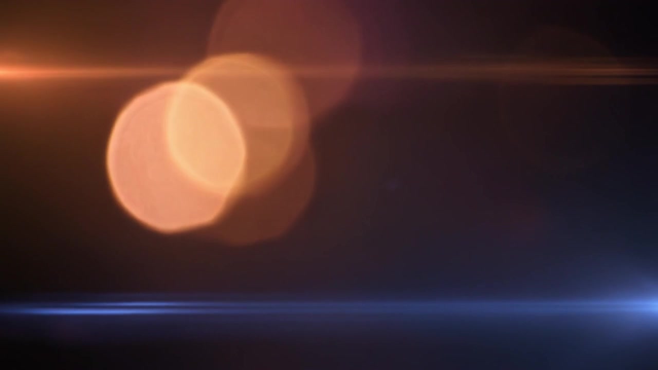 Flare anamorfico astratto con striature di luce arancioni e blu