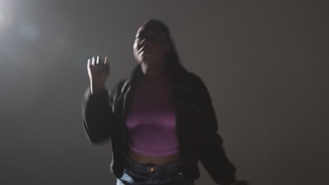 Studio-Portrait-Shot-Of-Young-Woman-Dancing-With-Low-Key-Lighting-Against-Grey-Background-12