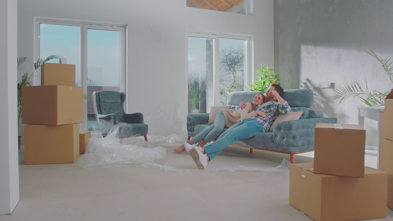 Glad par sidder på sofaen