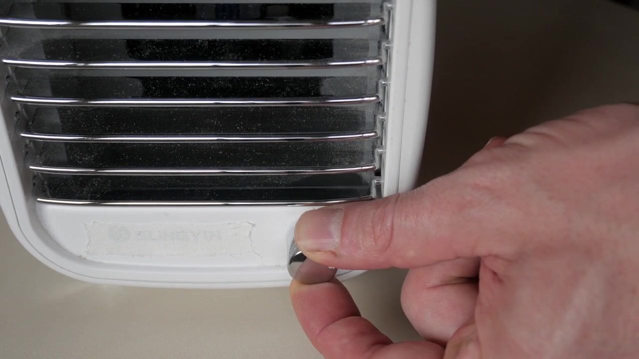 Male hand adjusts fan speed turning knob and tilts ventilation slats
