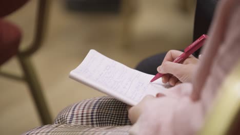 person taking notes during meeting or class