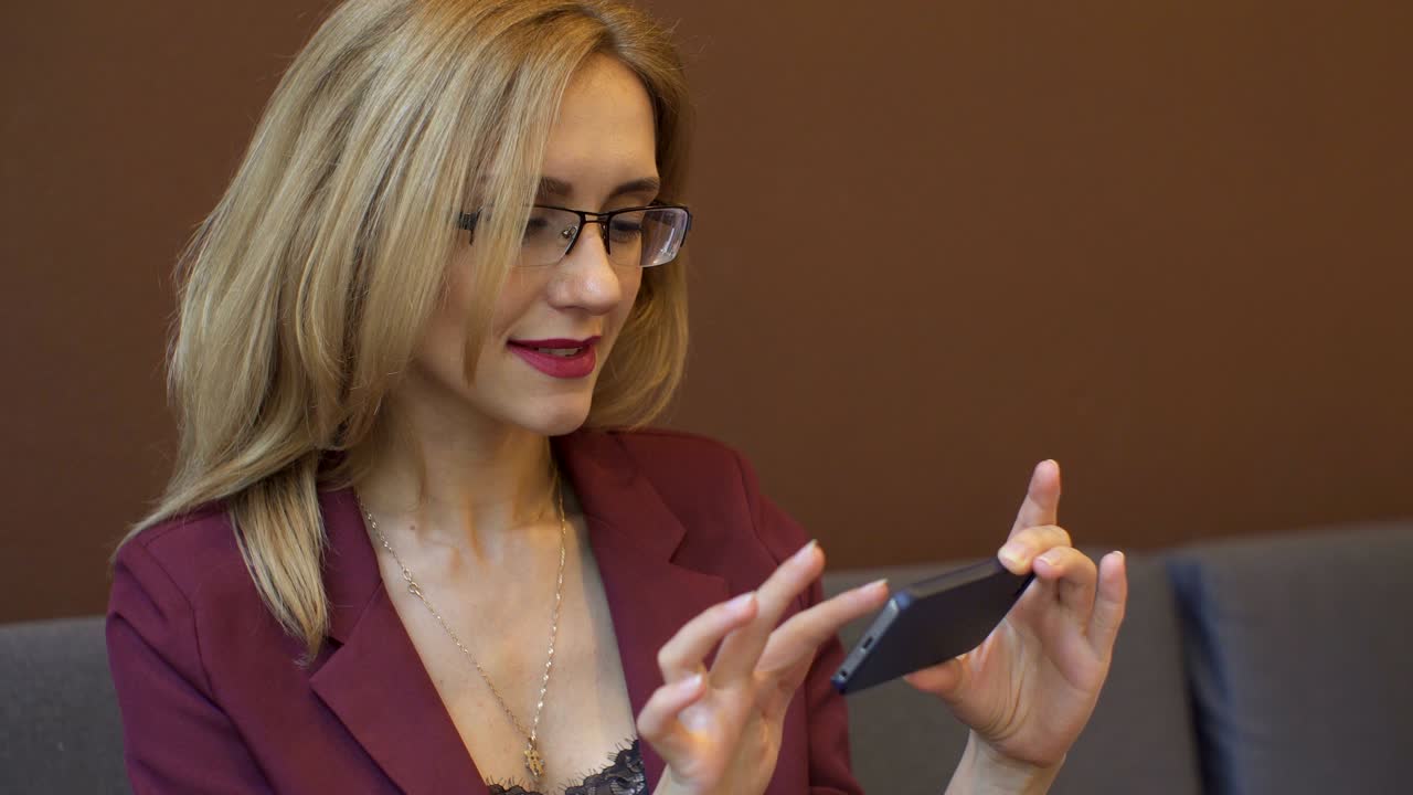 una mujer de negocios usando un teléfono inteligente en una cafetería.
