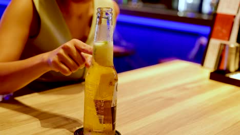 mujer bebiendo cerveza en un bar