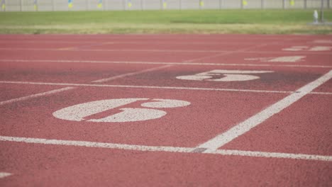 white markings on the red starting treadmill stadium seats with numbers.