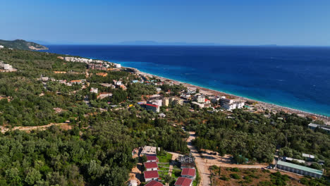 Aeria-view-circling-the-Gjilekë-town-on-the-Albanska-riviera,-in-sunny-Albania