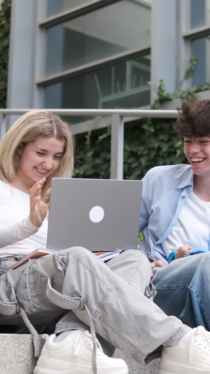 Young couple celebrating success while using laptop