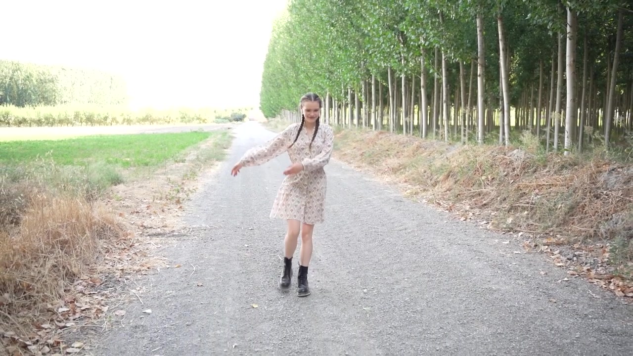 Una figura solitaria che passeggia lungo una bellissima strada di campagna alberata in una giornata tranquilla.