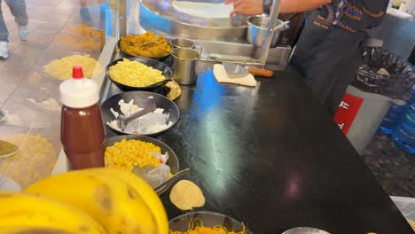 vendor prepares pancakes with bananas and toppings