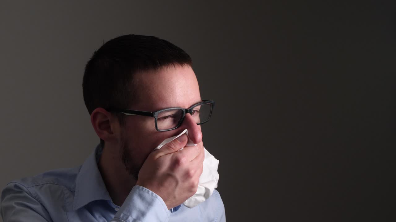 Giovane uomo tossisce energicamente e tiene un fazzoletto di carta sulla bocca per protezione - Slow Motion.