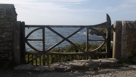 wide-shot-of-an-ornate-wooden-gate-at-Bessy's-Cove,-The-Enys