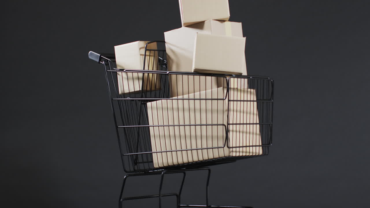 video de un carrito de compras y cajas con espacio de copia sobre un fondo gris