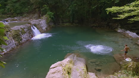 niños saltando a una piscina de montaña