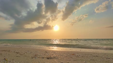 sunset at holbox punta cocos beach, waves crashing under soft golden light