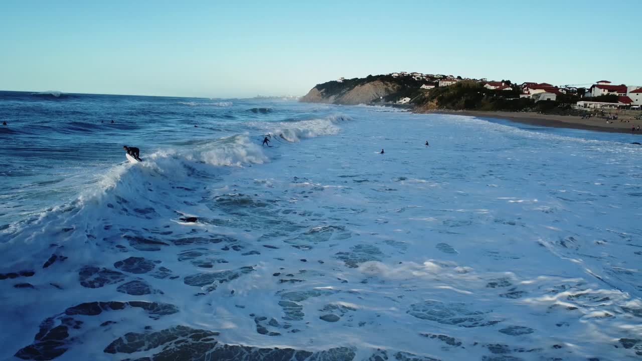 Ocean Waves with Surfers on a Sunny Day