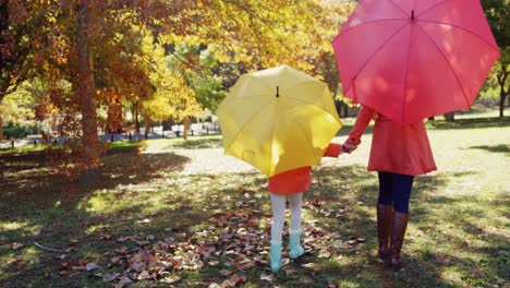 Mutter-Und-Tochter-Gehen-Mit-Sonnenschirmen-Im-Freien-Spazieren