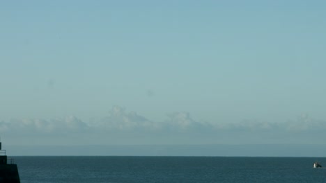 Swansea-Bay-West-Pier-Panning-Shot-to-Fisherman-Heading-Out-for-First-Catch-of-the-Day-4K