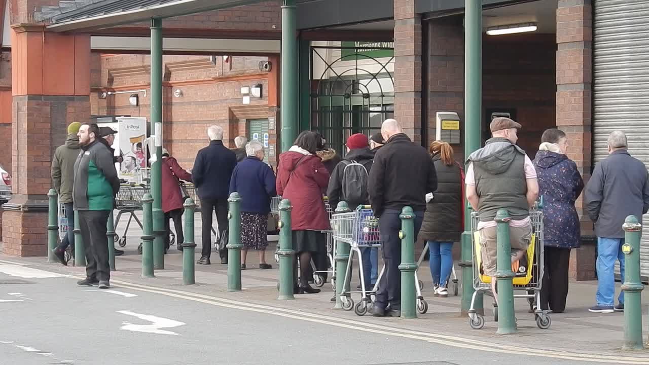 COVID Corona virus British social distancing queue at supermarket Morrisons store part J