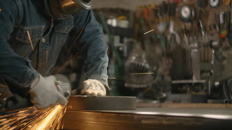 metalworker grinding metal in workshop