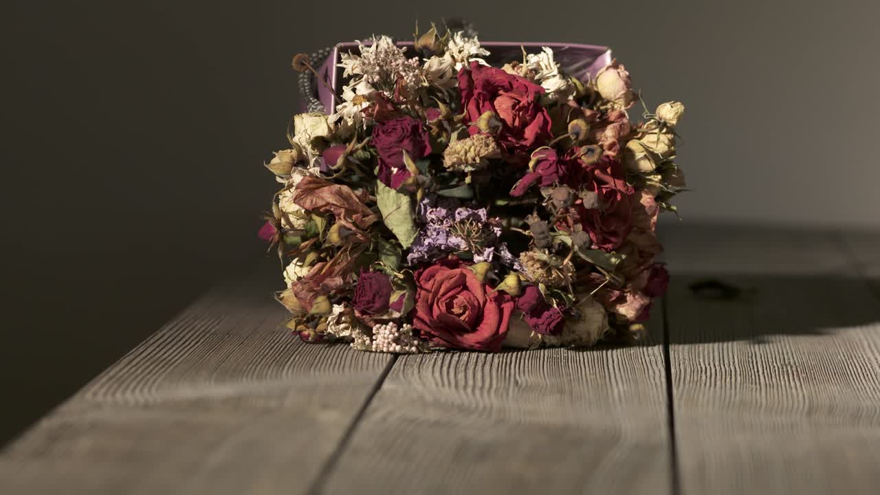 나무 테이블 위에 말린 꽃의 꽃줄기. 건조한 꽃 배열