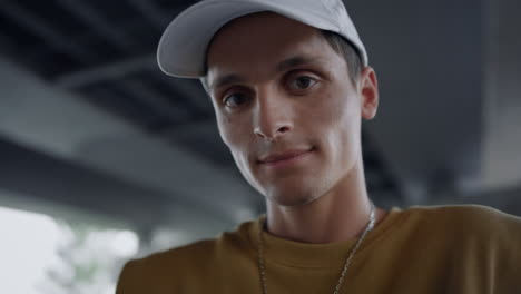 Happy-man-smiling-camera-at-skatepark.-Positive-guy-blinking-eyes-outdoors.