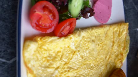 delicious breakfast omelet with croissant and salad