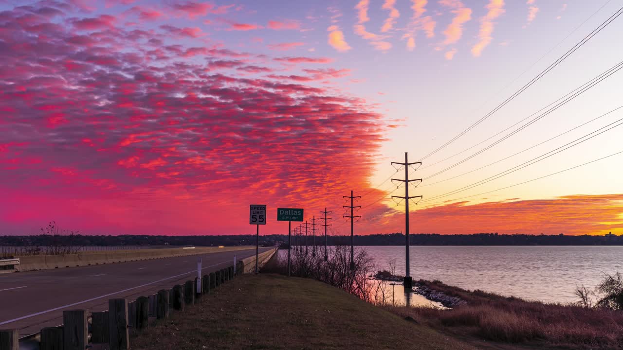 el lapso de tiempo de color rosa rojo naranja moteado cielo por encima de la carretera ocupada puente sobre el río que conduce a dallas