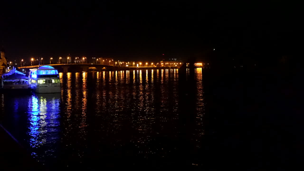 전경에서 보트와 함께 밤에 드네프르 강 위에 조명 다리