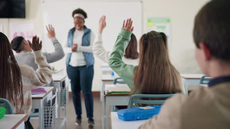 students raising hands in classroom