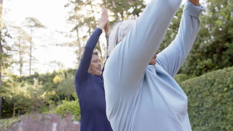 focused diverse senior couple practicing yoga meditation in garden