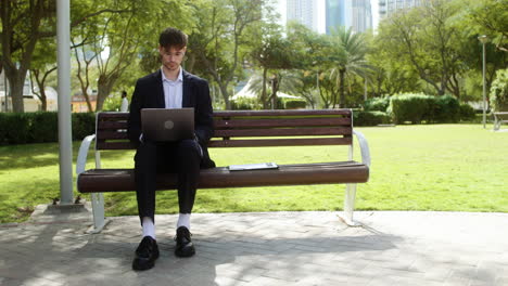 Man-sitting-on-the-bench-of-a-park