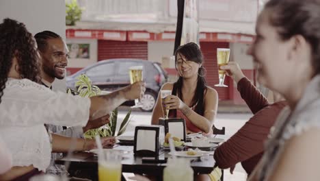 friends toasting with drinks at an outdoor cafe