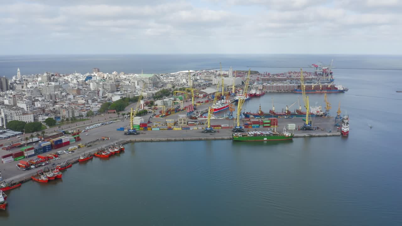 Uruguay capital city Montevideo. Forward moving aerial drone view of barrio Ciudad Vieja and harbour, seen from above the port. Calm cloudy weather
