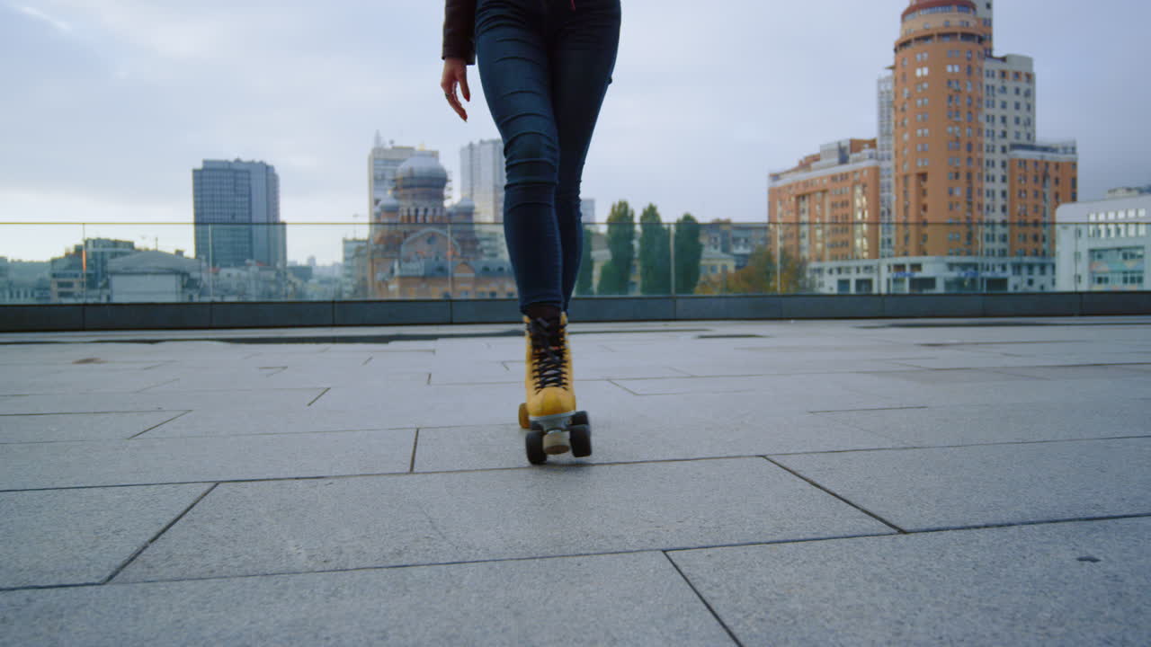 Unrecognizable woman having workout rollerblading workout at city rooftop.