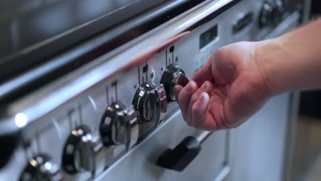 turning up the heat control knob on a cooker