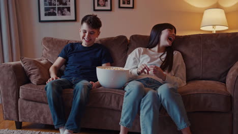 children sitting on a couch eating popcorn