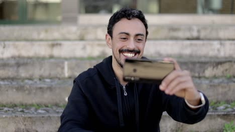 hombre alegre teniendo chat de video en la calle