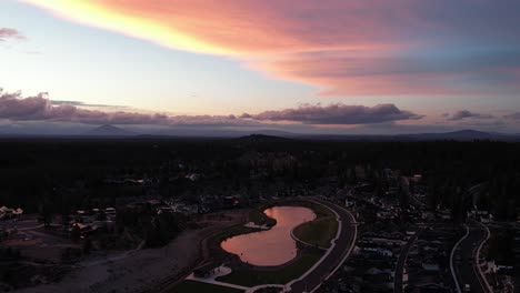 Aerial-view-of-neighborhood-in-Bend,-Oregon-with-a-lake-at-sunset