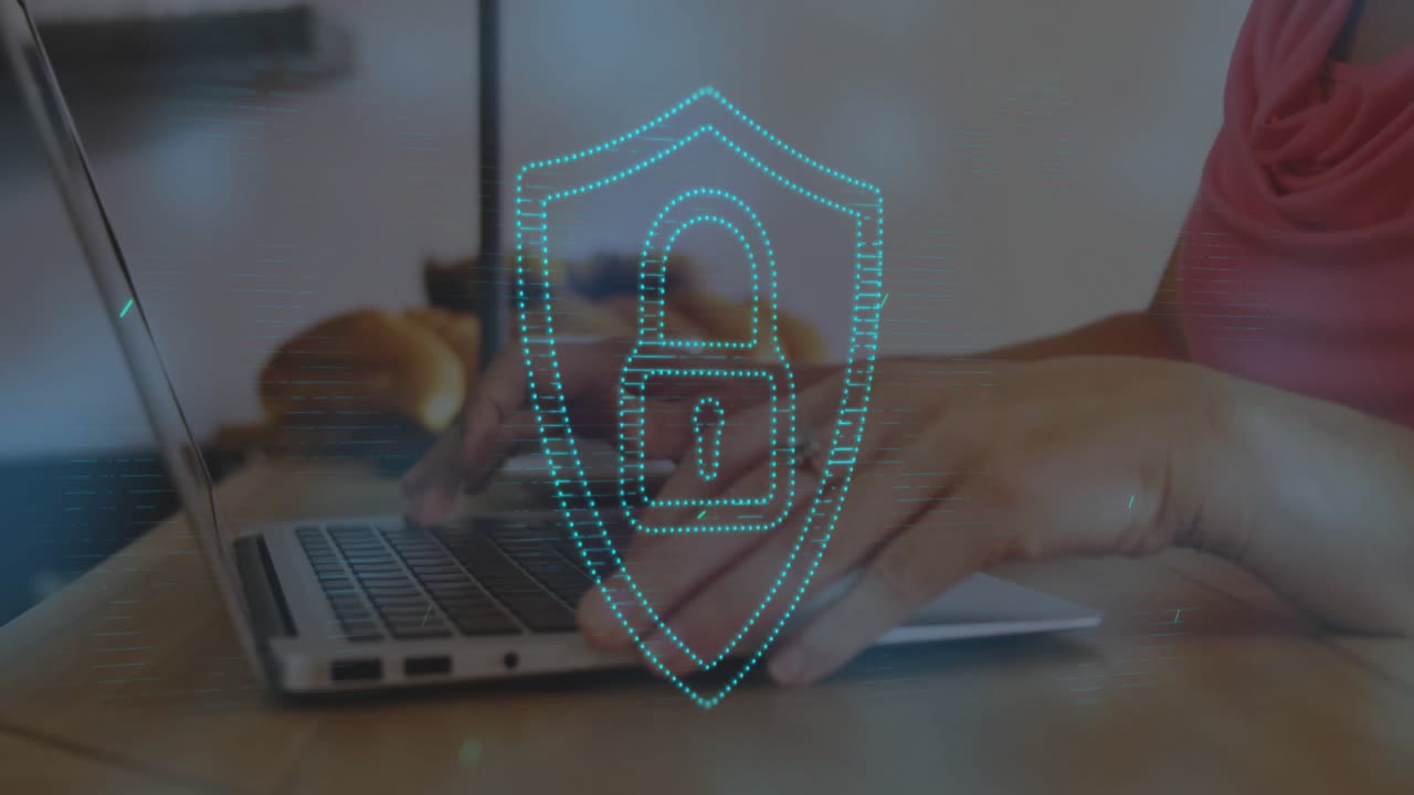 Icona di uno scudo che compare sul laptop mentre le mani digitano e una scansione di sicurezza con strisce di luce che passano
