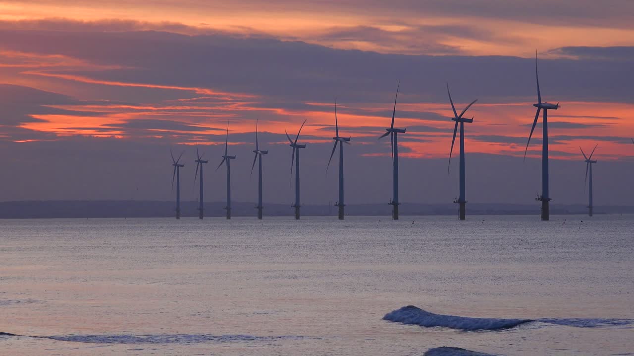 풍력 발전소는 일몰 2에서 해안선을 따라 전기를 생성합니다.