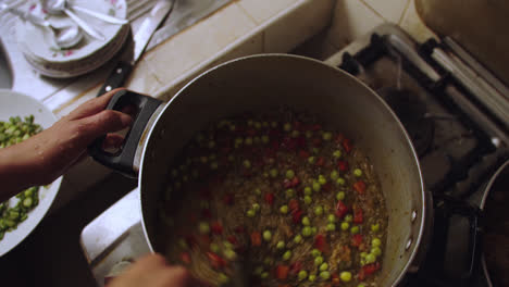 Mixing-ingredients-in-a-pot-to-prepare-Peruvian-dish-"Arroz-con-Pato