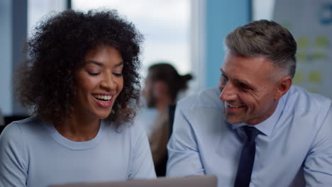 Smiling-businesswoman-and-businessman-looking-at-good-work-results-in-office